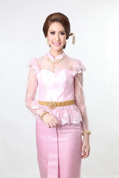 Elegant fashion brunette woman posing with creative chignon hair-style and wearing pink thai dress — Stock Photo, Image