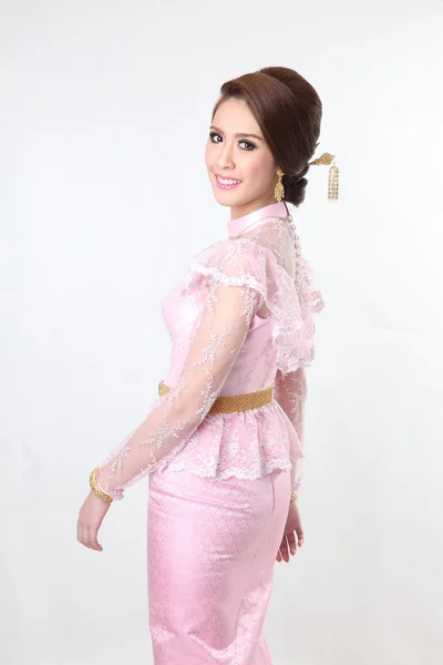 Elegant fashion brunette woman posing with creative chignon hair-style and wearing pink thai dress — Stock Photo, Image