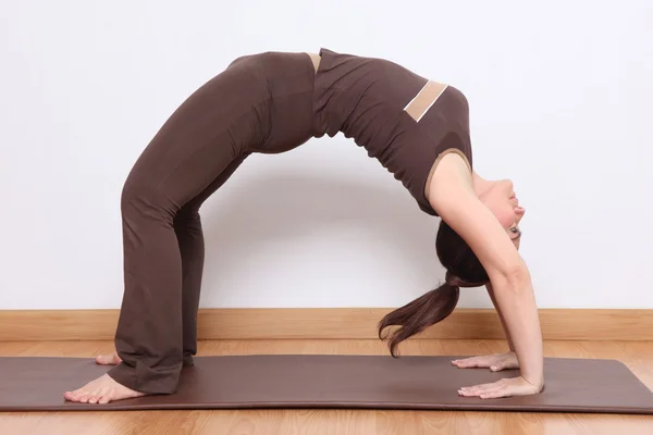 Femme faisant un exercice de yoga appelé Urdhva Dhanurasana — Photo