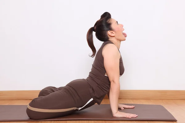 Donna che fa esercizio di yoga chiamato Simha-asana, La postura del leone Foto Stock