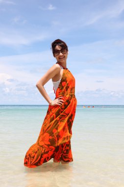 genç güzel kadın yazlık elbise ve plajda güneş gözlüğü