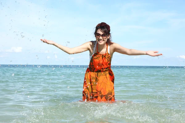 Belle jeune fille éclaboussant l'eau dans la mer — Photo