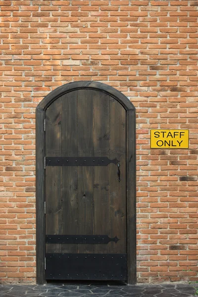 Porte fermée vintage en bois avec mur de briques à la maison — Photo