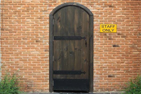 Porte fermée vintage en bois avec mur de briques à la maison — Photo