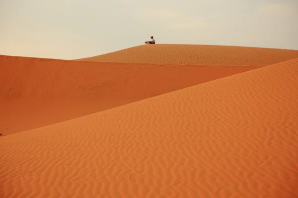 Muž sedící na písečných dunách — Stock fotografie