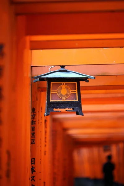Китайский фонарь в оранжевых воротах храма Инари Таиша в Фушими — стоковое фото