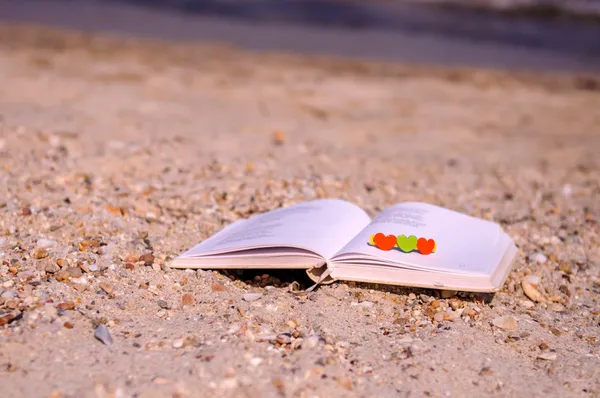 Livro aberto na praia com corações pequenos — Fotografia de Stock