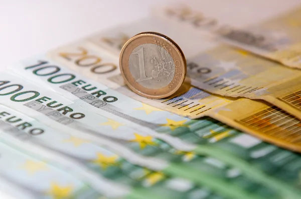 Seiscientos euros y monedas en una mesa blanca — Foto de Stock
