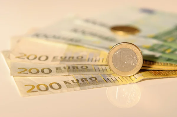 Euros, cien, doscientos y monedas en una mesa blanca — Foto de Stock