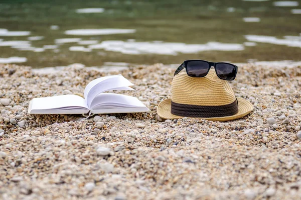 Boek bij strand tijdens de zomer lezing — Stockfoto