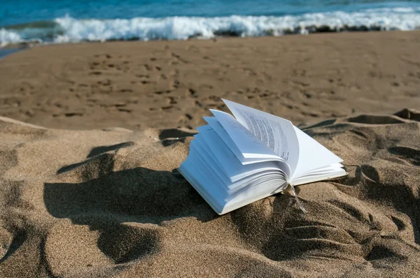 Boek bij strand in de zomer in de buurt van de zee — Stockfoto