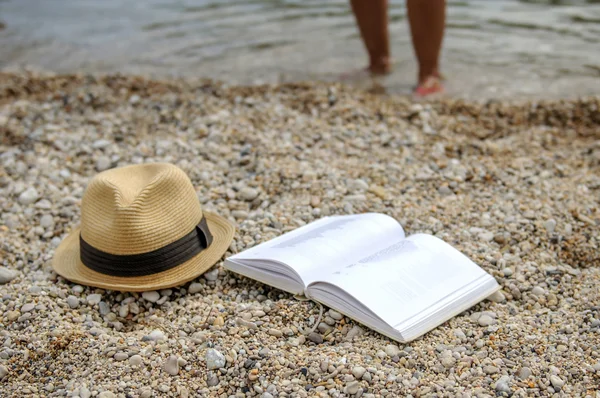 Boek bij strand lezing tijdens de zomer Stockafbeelding