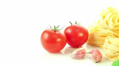 İtalyan gıda maddeleri üzerinde beyaz arka plan, makarna, sarımsak ve fesleğen ile domates