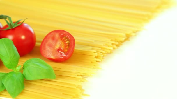 Italiensk matingredienser på vit bakgrund, tomat med pasta spagetti och basilika — Stockvideo