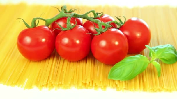 Italian food ingredients on white background, tomato with pasta spaghetti, garlic and basil — Stock Video