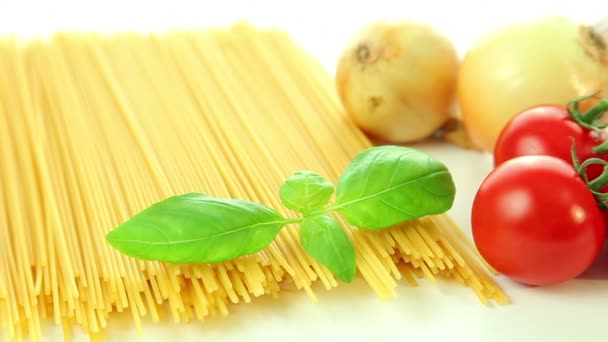 Italian food ingredients on white background, tomatoes with pasta spaghetti, garlic and basil — Stock Video