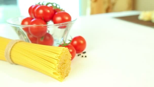 Ingredientes de la comida italiana en fondo blanco, tomate con pasta espagueti, pimienta y albahaca — Vídeo de stock