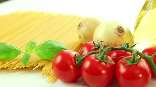 Beyaz arka plan, domates makarna spagetti, sarımsak, biber, soğan, zeytin yağı ve fesleğen ile İtalyan gıda maddeleri — Stok video