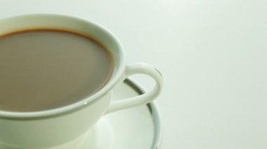 Beyaz arka planda sütlü bir fincan kahve.