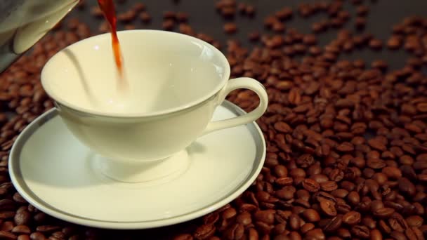 Čerstvé horkou kávu, bílý šálek na kávová zrna pozadí — Stock video