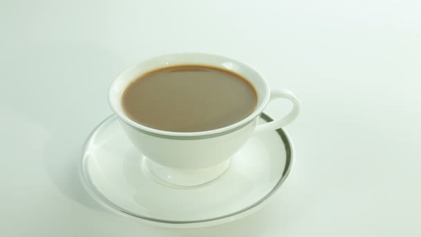 Ένα φλιτζάνι καφέ με γάλα σε λευκό φόντο — Αρχείο Βίντεο