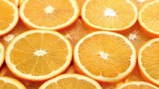 Cortou fatias de laranja, frescas e suculentas de fundo laranja movimento — Vídeo de Stock