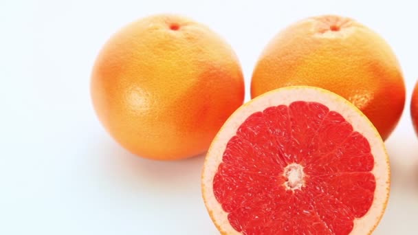 Rode grapefruit vruchten op witte achtergrond — Stockvideo