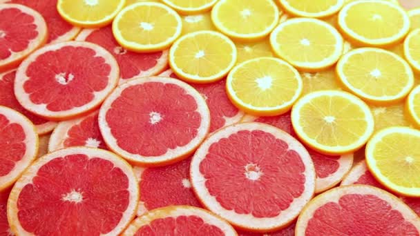 Gesneden grapefruit met oranje, beweging achtergrond — Stockvideo