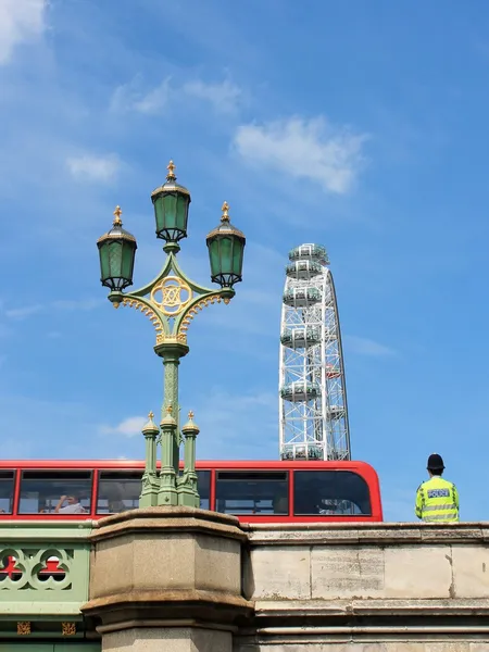 Londres símbolos, olho de Londres, ônibus vermelho, policial e ponte de Westminster — Fotografia de Stock