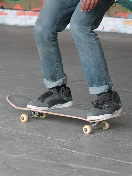 Gördeszka a skate park tinédzser korcsolyázó-és gördeszka lábak Skate Park graffiti mögött — Stock Fotó