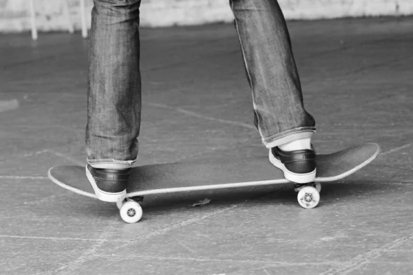 Skateboard at skate park Teenager skater and skateboard legs in skate park with graffiti behind — Stock Photo, Image
