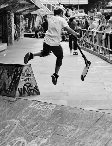 Adolescente criança fazendo um salto no ar em scooter — Fotografia de Stock