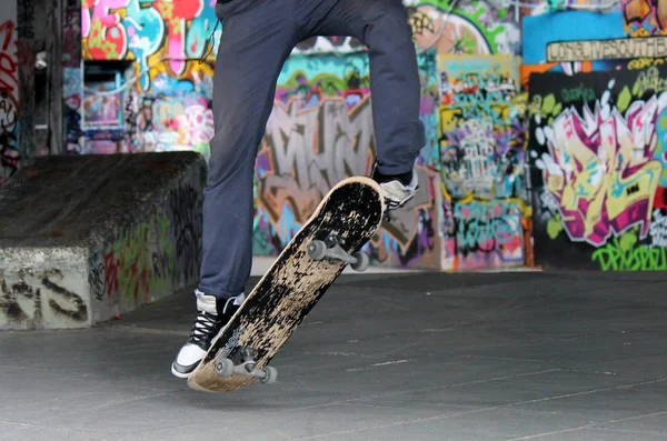 Gördeszka a skate park tinédzser korcsolyázó-és gördeszka lábak Skate Park graffiti mögött — Stock Fotó