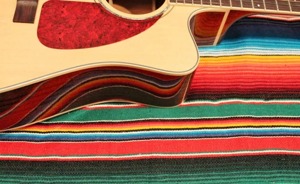 Alfombra de poncho de fiesta de México en fondo de rayas brillantes con espacio para copiar — Foto de Stock