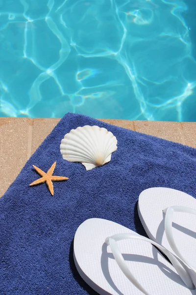 Poolside holiday vacation scenic swimming pool summer shell towel flip flops thongs — Stock Photo, Image