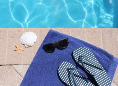 havuz kenarında tatil tatil doğal yüzme havuzu yaz güneş gözlükleri, kabuk, havlu ve parmak arası terlik şeyler