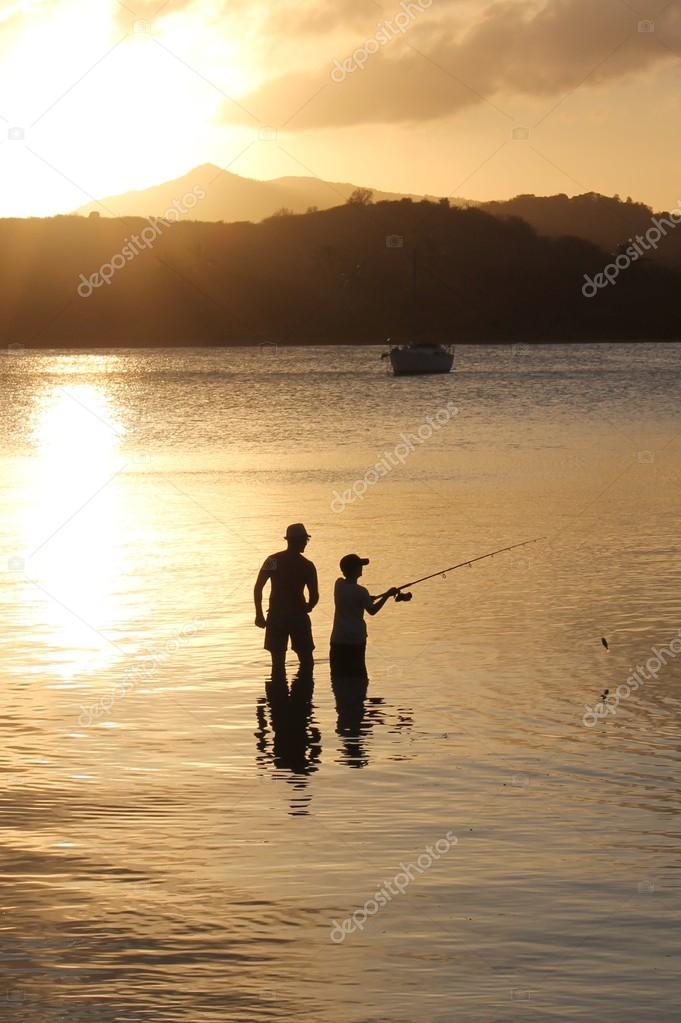 father and son family fishing at sunset