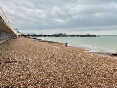 Hastings, Doğu Sussex, İngiltere - 05.03.2022: Hastings rıhtımı ve sahil şeridi, çakıl taşı plajı ve bulutlar 
