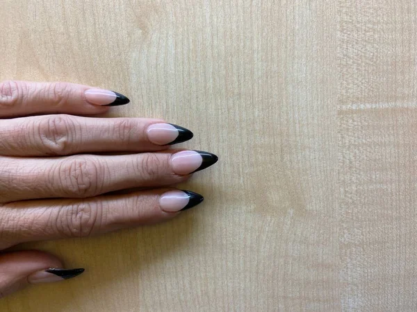 Black tip  flesh nude French manicure with claw points trendy nail design in acrylic applied nail art
