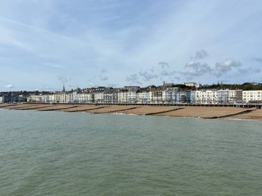 Hastings, Doğu Sussex, İngiltere - 20.4.2022: Hastings rıhtımı ve İngiltere 'nin doğu Sussex İngiltere sahil beldesi Hastings' in sahil kulübeleri