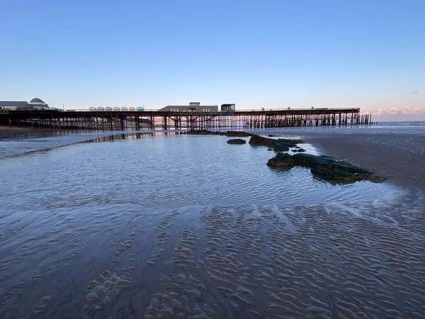 Hastings, Doğu Sussex, İngiltere - 20.4.2022: Hastings rıhtımı ve İngiltere 'nin doğu Sussex İngiltere sahil beldesi Hastings' in sahil kulübeleri