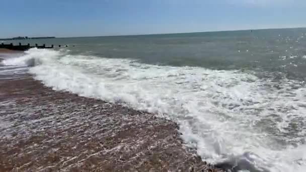 背景波の上から波が打ち寄せる小石の砂浜 — ストック動画