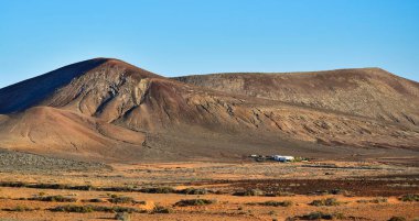 Önünde beyaz bir ev olan güzel volkanik bir manzara. Costa Teguise yakınlarında, Lanzarote, Kanarya Adaları, İspanya. Görüntü kamusal alandan alındı.