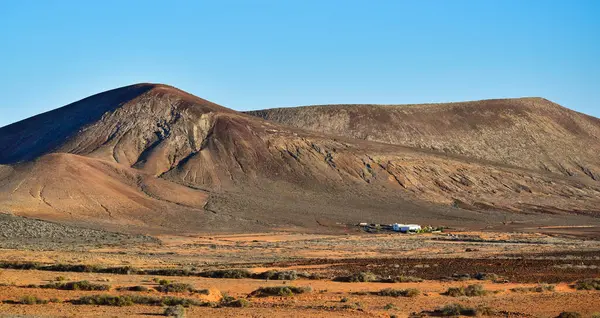 Önünde beyaz bir ev olan güzel volkanik bir manzara. Costa Teguise yakınlarında, Lanzarote, Kanarya Adaları, İspanya. Görüntü kamusal alandan alındı.