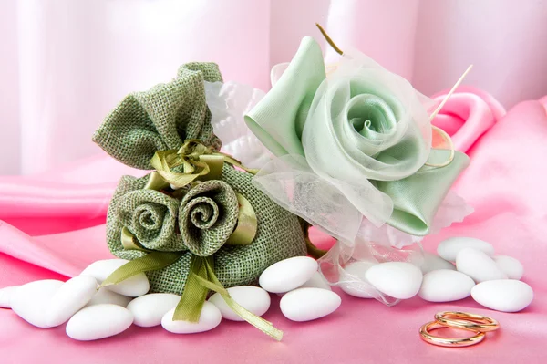 Wedding rings and favors on elegant fabric — Stock Photo, Image