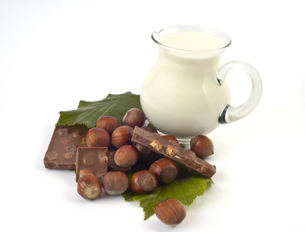 Chocolate with hazelnuts and white milk jug — Stock Photo, Image