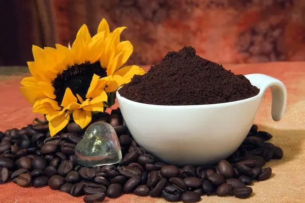 Cup met koffie poeder en koffie bonen verspreid — Stockfoto