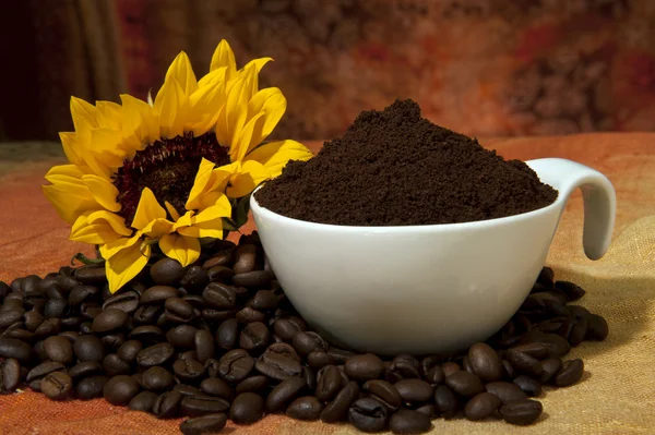 Cup met koffie poeder en koffie bonen verspreid — Stockfoto