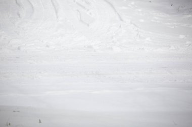 Kışın yağışla kaplı tehlikeli kaygan bir yolda lastik izleri.