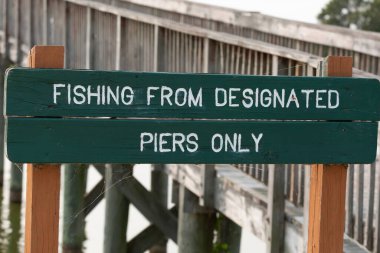 POVERTY POINT RESERVOIR PARK, DELHI, LOUISIANA / UNITED Eyaletleri - 11 Eylül 2021: Delhi, Louisiana 'nın dışındaki Poverty Point Reservoir State Park' taki yeşil işaret, ziyaretçilerin sadece belirlenmiş rıhtımlardan balık tutabildiklerini belirtiyor. Tahta kaldırım gelini